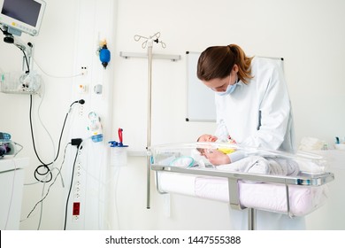 Nurse In ICU Examining Premature Born Child