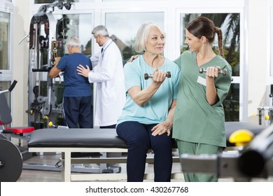 Nurse Instructing Senior Patient Exercising With Dumbbell