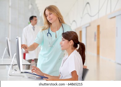 Nurse With Intern Working In Front Of Computer