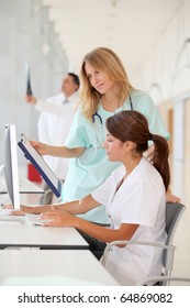 Nurse With Intern Working In Front Of Computer
