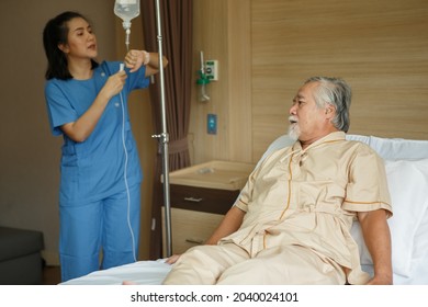 Nurse  IV Drip  With Asian Senior Man Patient Lying On Bed In Hospital Ward . 