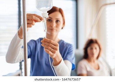 A nurse with IV drip and patient in bed in hospital room. - Powered by Shutterstock
