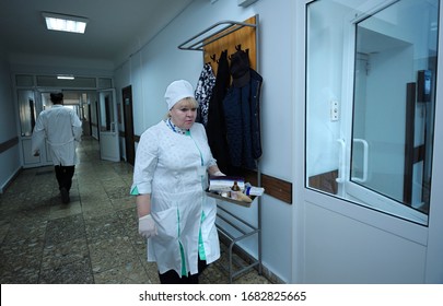 Nurse In A Lab Coat Walking Through Lobby Of A Hospital Carrying Tray With Medication For Patients. February 2, 2020. Kiev, Ukraine