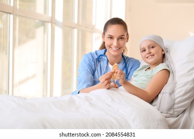 Nurse and little girl with golden ribbon in clinic. Childhood cancer awareness concept - Shutterstock ID 2084554831