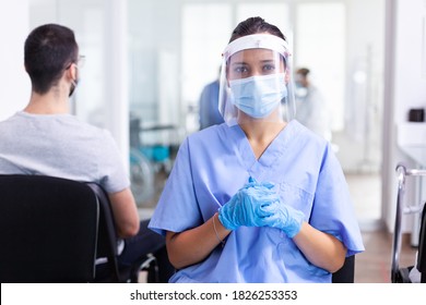 Nurse Looking At Camera Wearing Surgical Face Mask Against Coronavirus In Hospital Hallway As Safety Precaution. Physician, Epidemic, Care, Surgical, Corridor.