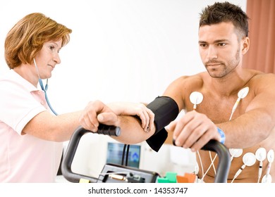 Nurse Makes The Patient Ready For Medical EKG Test. Real People, Real Locacion, Not A Staged Photo With Models.