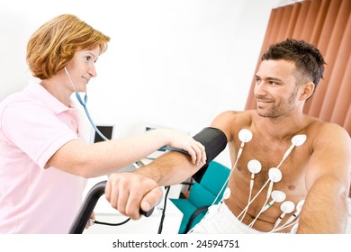 Nurse Makes The Patient Ready For Medical EKG Test. Real People, Real Locacion, Not A Staged Photo With Models.