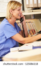 Nurse Making Phone Call At Nurses Station