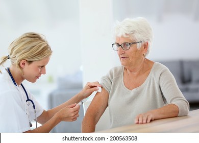 Nurse Making Vaccine Injection To Elderly Patient