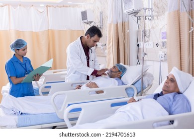 Nurse with male doctor examining of patient lying on icu bed at hospital - Powered by Shutterstock