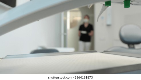 A nurse in a mask carries a tray with disinfected instruments to start a dental surgery. Dentistry and dental treatment in a state-of-the-art clinic. - Powered by Shutterstock