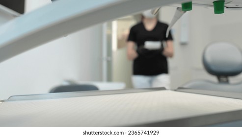 A nurse in a mask carries a tray with disinfected instruments to start a dental surgery. Dentistry and dental treatment in a state-of-the-art clinic. - Shutterstock ID 2365741929