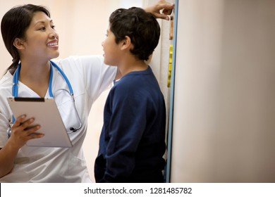 Nurse Measuring A Young Boys Height.