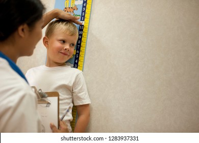 Nurse Measuring A Young Boys Height.