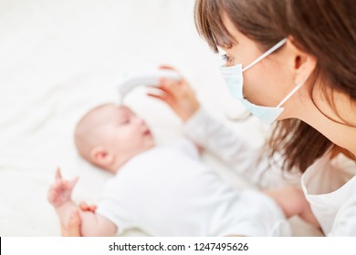 Nurse With Medical Mask Measures Fever In Sick Baby