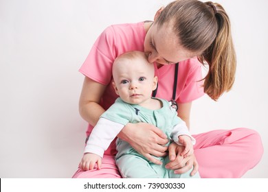 Nurse Mom With Baby Boy Dressed Up In Scrubs