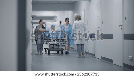 Nurse and mother of child push gurney with young girl in clinic hallway. Female doctor meets lying on stretcher kid and talks with her before operation. Medical personnel work in emergency department. ストックフォト © 