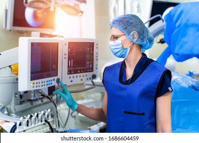 Nurse near the screen of mechanical ventilation equipment. Hospital, surgical operating room. Life saving. Ventilation of the lungs with oxygen. Pneumonia diagnosting. COVID-19