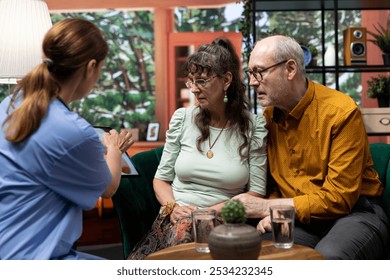 Nurse offering medical support and explaining cardiovascular system with illustrations, talking about heart condition and medication. Assistance to elderly couple during a home visit. - Powered by Shutterstock