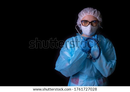 A nurse on a black background in a protective uniform.