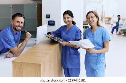 Nurse on duty talking with medical assistants during working day in medical clinic standing near reception desk at hospital lobby. Medical staff of clinic - Shutterstock ID 2199446581