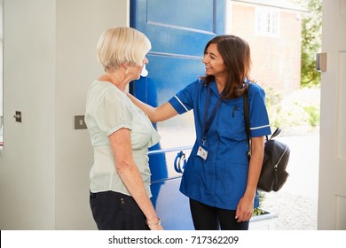 Nurse on home visit greets senior woman at her front door