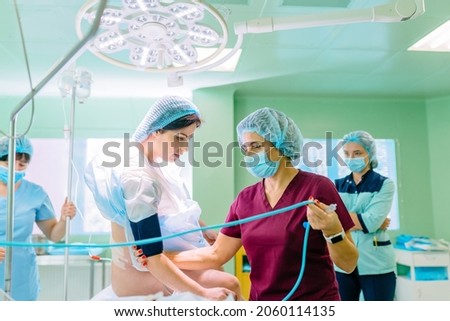 Nurse operating room composition help female patient the anesthesiologist works in the operating room with two assistants. Medical background.