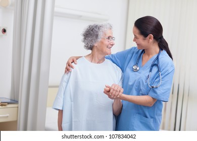 Nurse And A Patient Standing In Hospital Ward