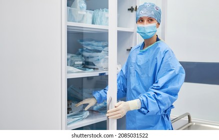 Nurse Picks Up Nursing Supplies And Medication From A Cabinet In The Hospital