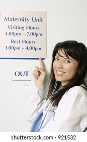 A Nurse Pointing To The Hospital Visiting Hours Sign