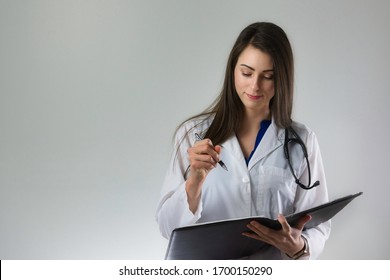 Nurse Practitioner Or Female Doctor Writing Prescription On Tablet Of Paper. Pen In Hand, Conducting Patient Care