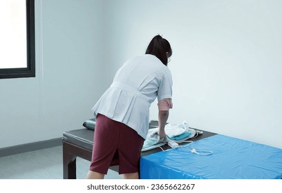 The nurse is preparing to clean the bed to accommodate new patients. - Shutterstock ID 2365662267