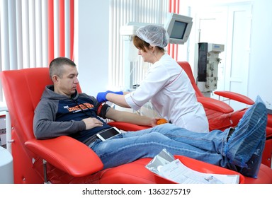 Nurse Preparing A Donor For Taking Blood From The Vain. The City (municipal) Blood Transfusion Station. April 5, 2019. Kiev, Ukraine