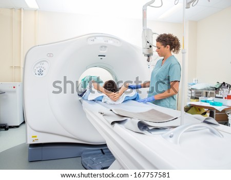 Nurse preparing patient for CT scan in hospital room