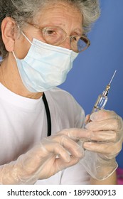 Nurse with protective mask and gloves prepares injection of vaccine or medicine for disease prevention with glass syringe and large needle