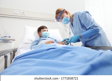 Nurse With Pulse Oximeter On Patient Child In Hospital Bed, Wearing Protective Visor Mask, Corona Virus Covid 19 Protection Concept, 