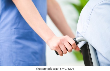 Nurse Pushing A Patient's Wheelchair