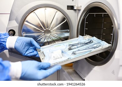 Nurse putting instruments in special craft paper bags into autoclave for processing.Laboratory equipment. Tools sterilization, bacterial purification and disinfection in dental clinic. Selective focus - Shutterstock ID 1941264526