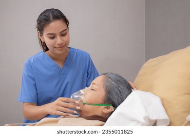 Nurse putting oxygen mask with patient elderly woman on bed for diagnose and healing in hospital, specialist doctor giving oxygen mask with senior emergency for recovery in clinic, medical concept. - Powered by Shutterstock