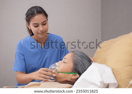 Nurse putting oxygen mask with patient elderly woman on bed for diagnose and healing in hospital, specialist doctor giving oxygen mask with senior emergency for recovery in clinic, medical concept.