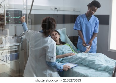 Nurse Putting Pulse Oximeter On Patient Finger While Doctor Setting Up Central Line Catether With Iv Drip Medication. Woman In Hospital Bed With Low Oxygen Saturation Recieving Medical Care.