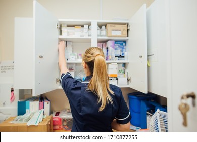 Nurse Reaching Into Medical Supplies Cupboard