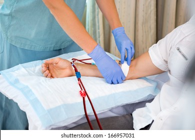 Nurse in renal unit at hospital starting dialysis on patient