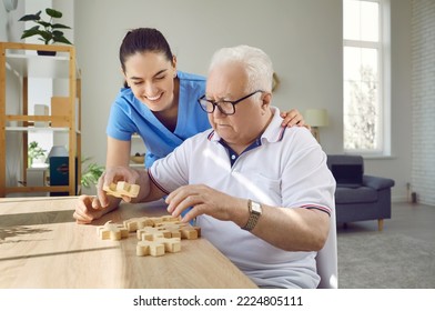 Nurse in retirement home helping old male patient with board game. Senior man with cognitive disorder sitting at table in geriatric clinic, playing games and thinking. Dementia, Alzheimers, care - Powered by Shutterstock