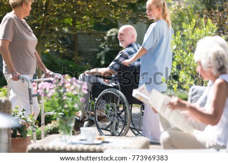 Similar – Woman carrying her mother in a wheelchair