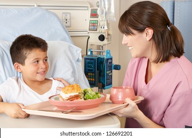 Nurse Serving Child Patient Meal In Hospital Bed