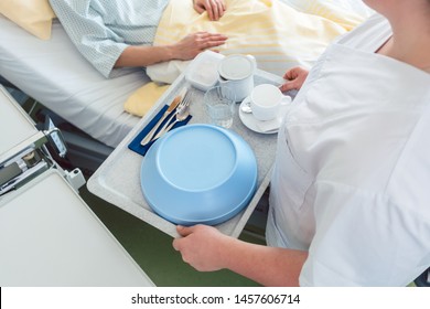 Nurse Serving Food In The Hospital To A Patient In Bed, Top View