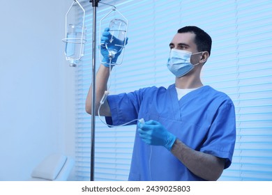 Nurse setting up IV drip in hospital - Powered by Shutterstock