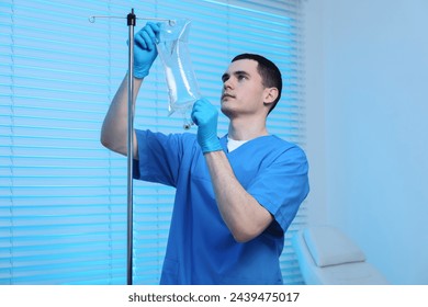 Nurse setting up IV drip in hospital - Powered by Shutterstock