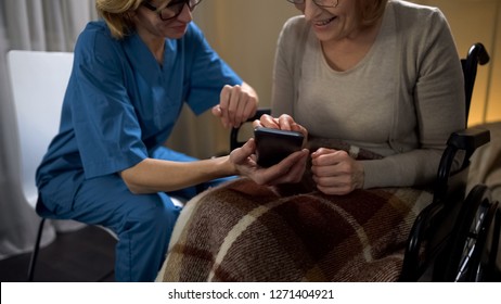 Nurse Showing Senior Woman How To Use Cell Phone, Easy Online Shopping App